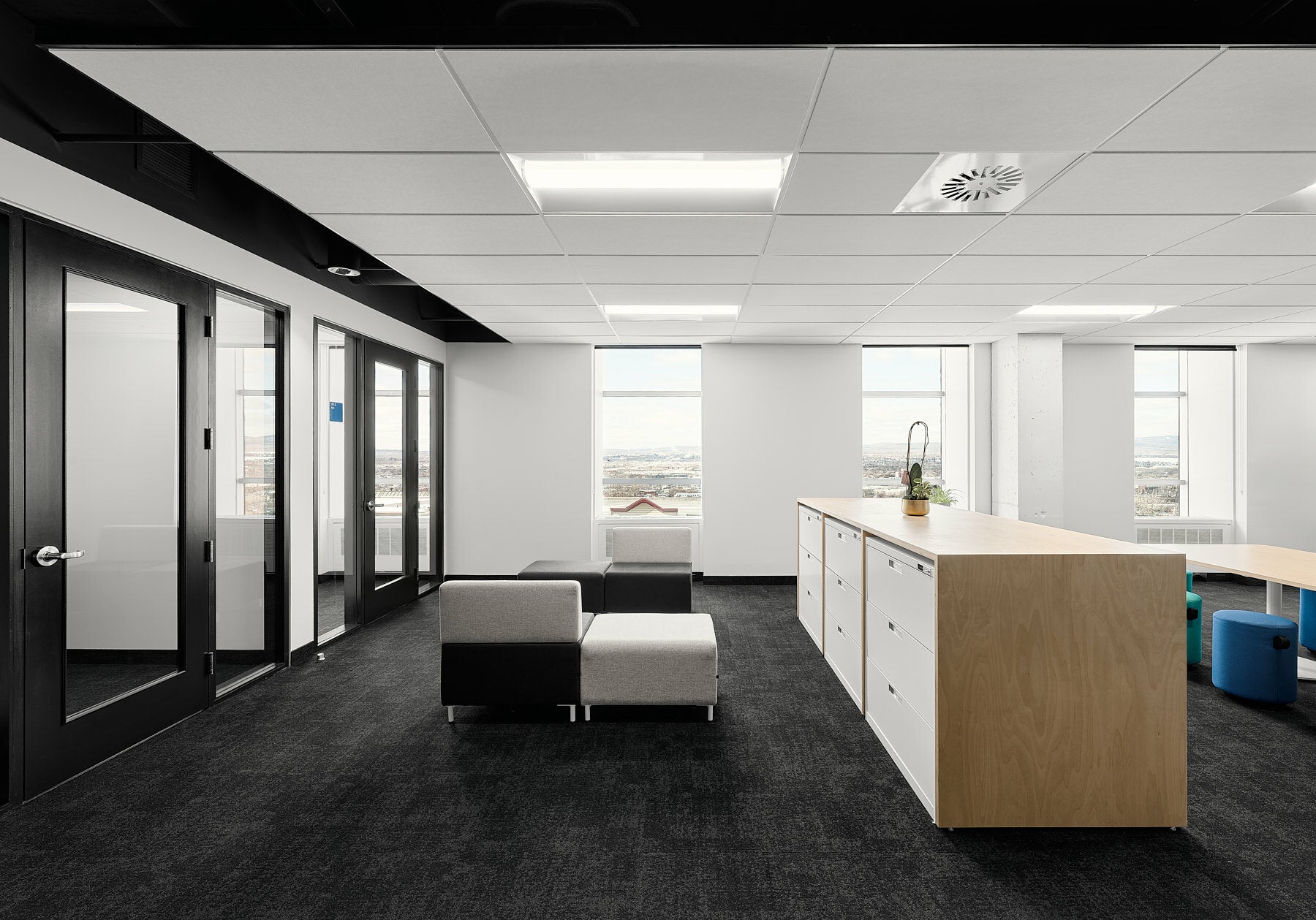 Modern office interior with a kitchen island and glass doors.