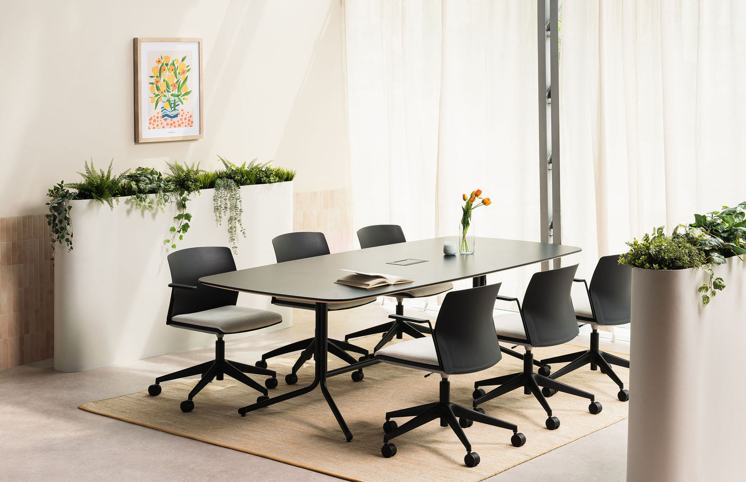 Modern conference room with a table and chairs, plants, and a decorative wall art.