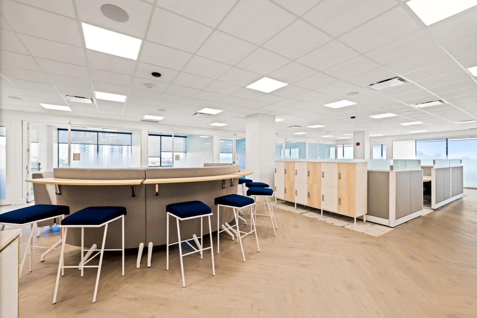 Modern office space with wooden desks and stools.