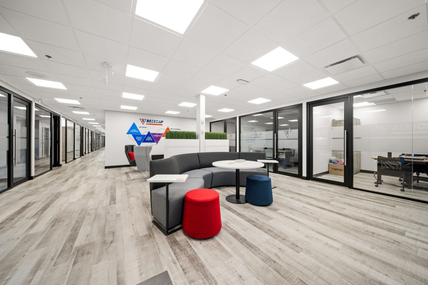 Modern office interior with a sofa, coffee table, and glass walls.