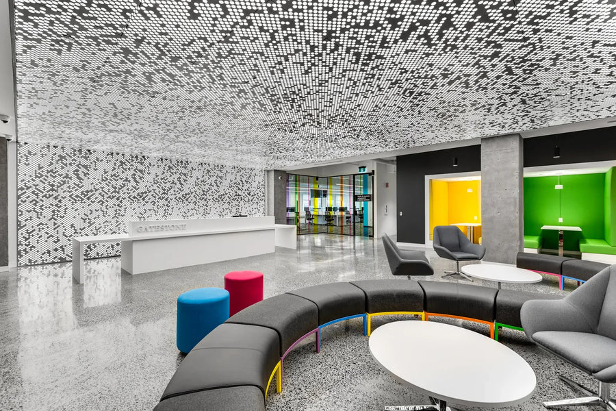 Modern office lobby with colorful seating area and patterned ceiling
