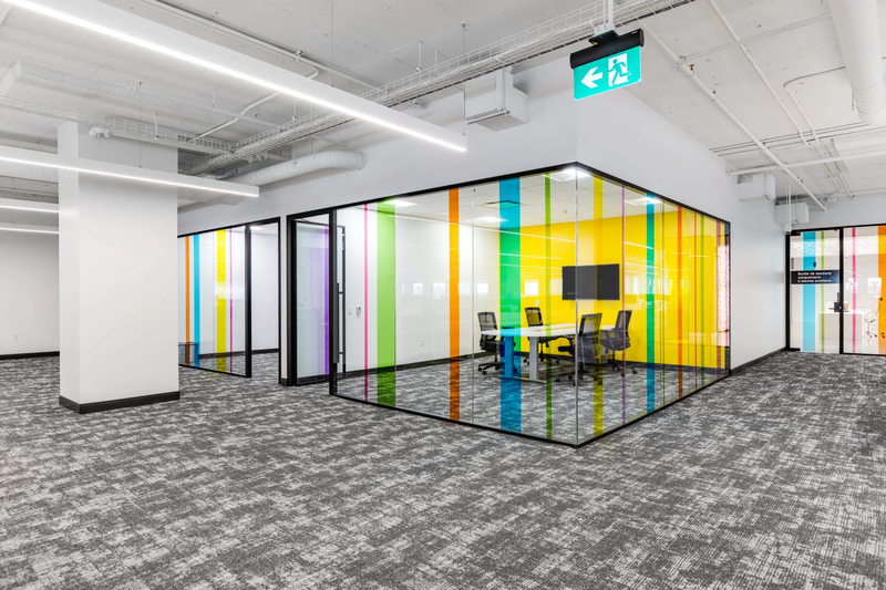 Modern office space with colorful glass partition walls.