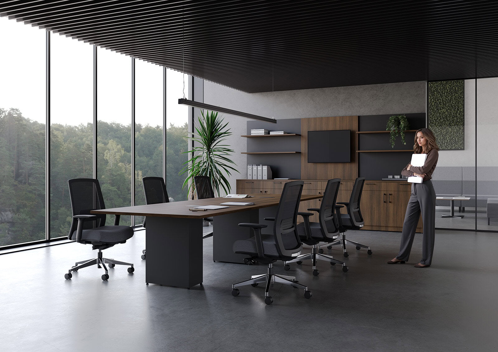 Modern office interior with a woman standing near a desk.