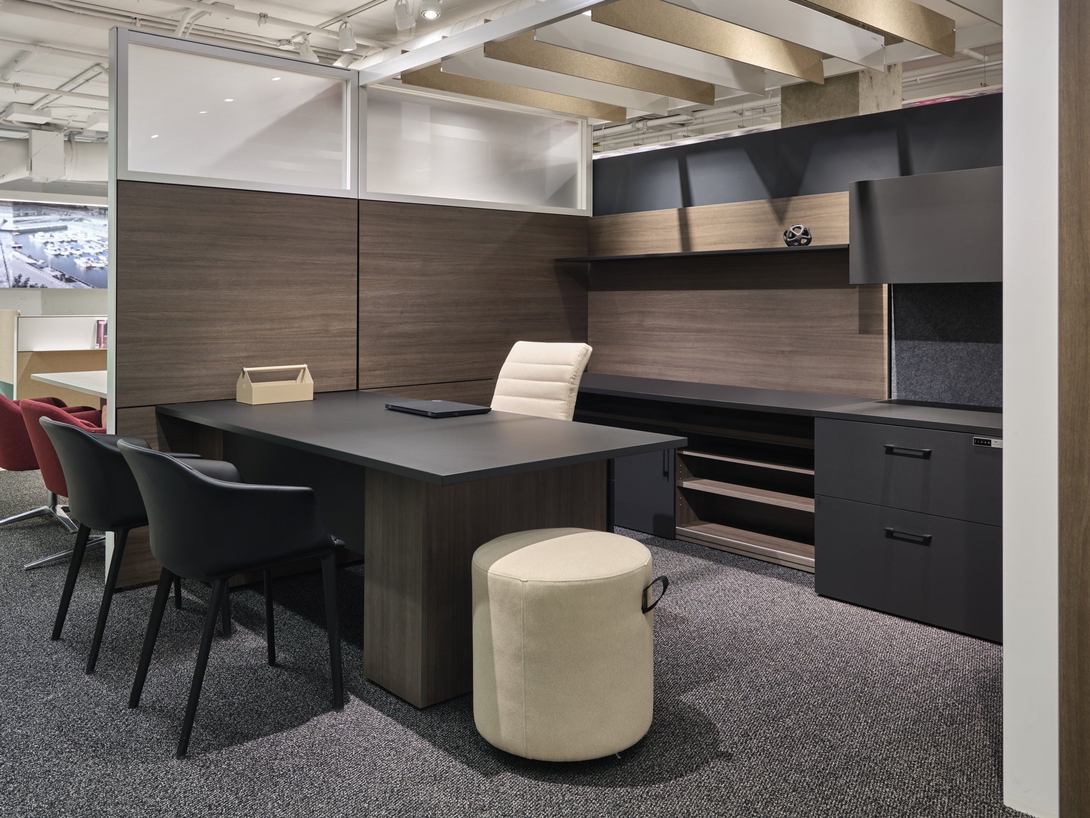 Modern office setup with a large desk, chairs, and a cabinet.