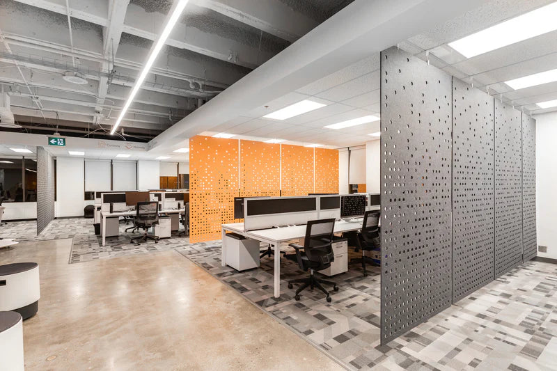 Modern office space with desks, chairs, and decorative walls.