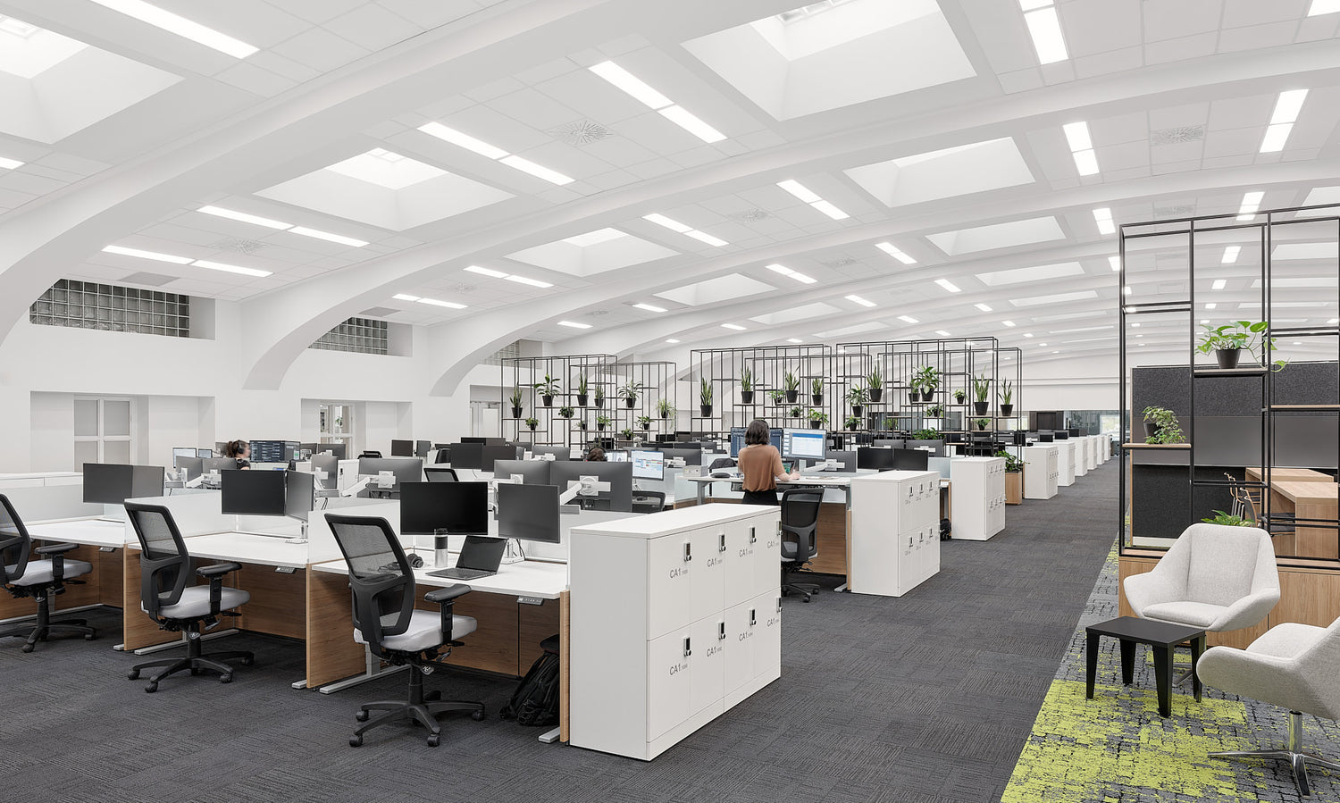 Modern office space with desks, chairs, and plants.