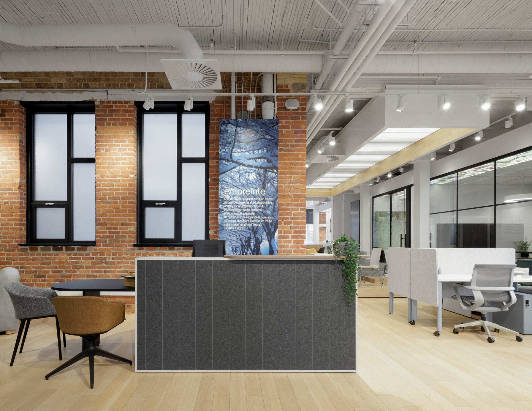 Modern office interior with a reception desk, chairs, and glass partitions.