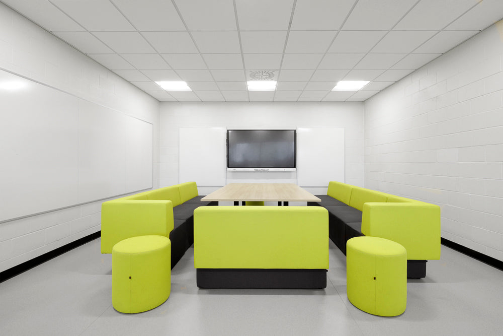 Modern office waiting area with green and black furniture and a TV on the wall.