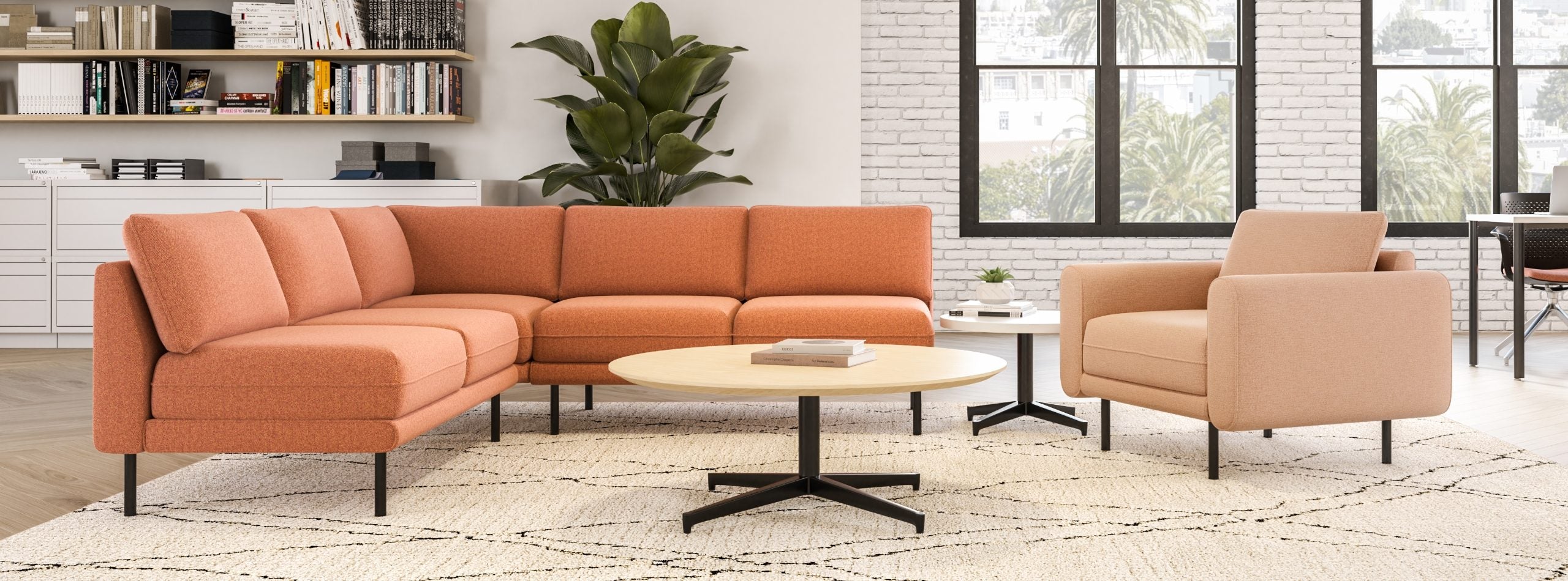 Orange sectional sofa and armchair in a modern living room with large windows.