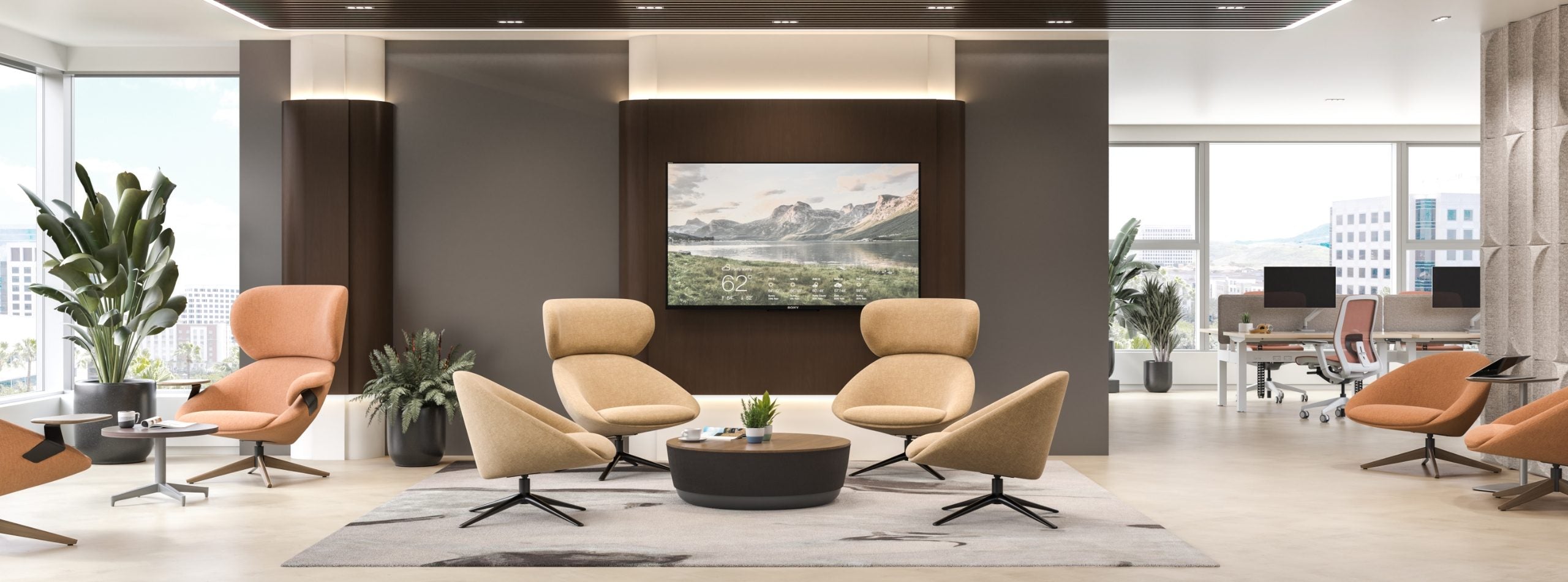 Modern office waiting area with beige chairs, a coffee table, and a large TV screen displaying a scenic image.